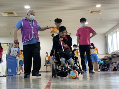 院生小純(中 )在同學協助下開心完成輪椅曲棍球進球