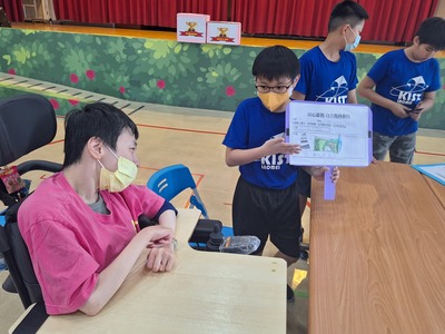 學童拿著親手繪畫向院生小汝介紹石門景點