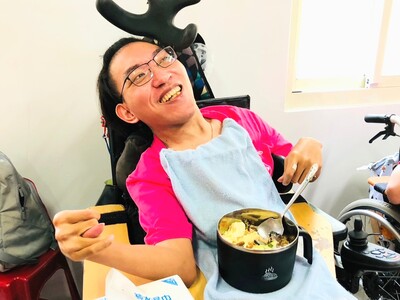 重度障礙院生阿傑開心吃著志工們精心準備的美味餐食