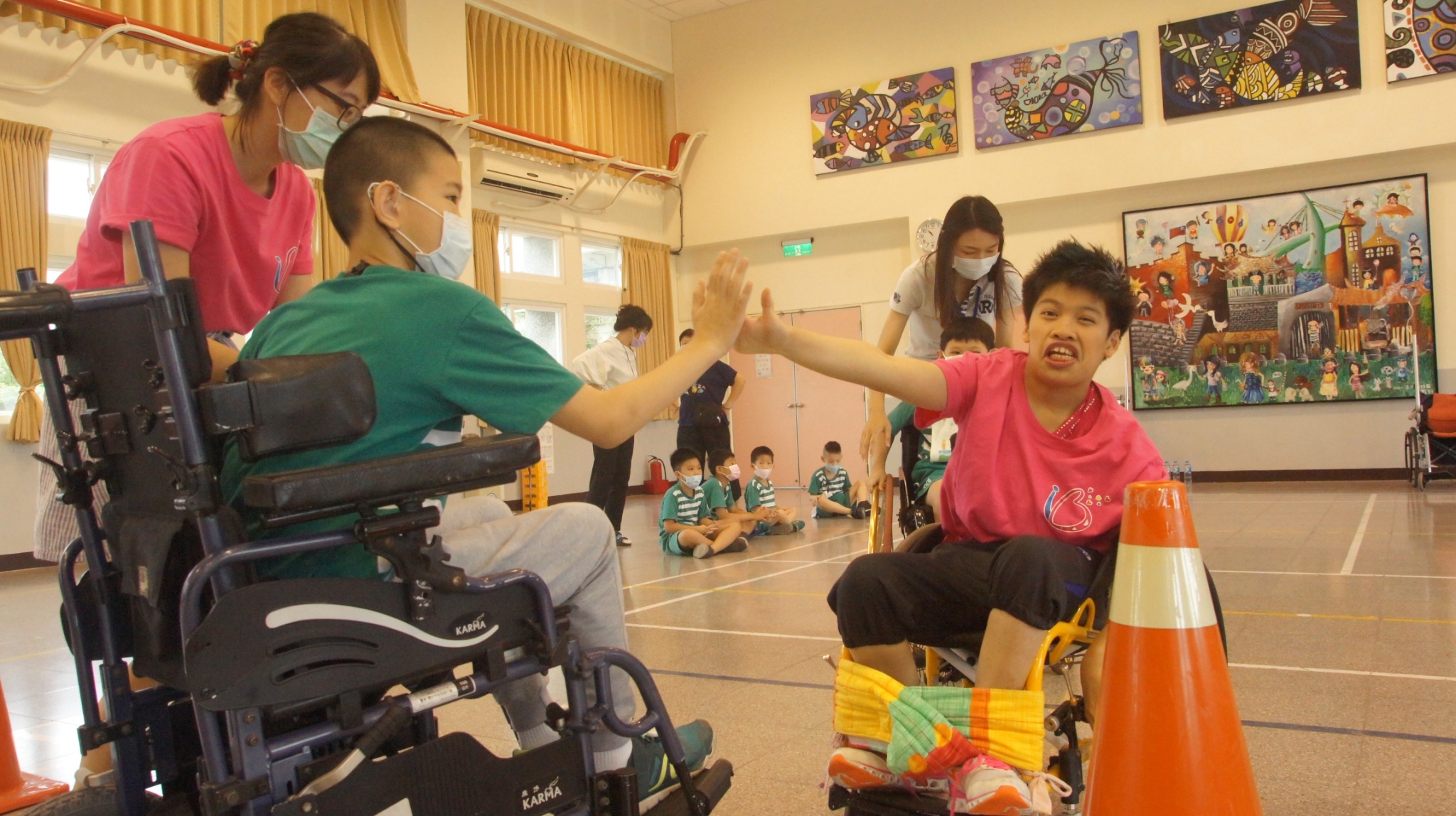小瑄（右）與淡水國小學生比賽輪椅競速 學生敬佩小瑄的精神 與她開心擊掌-